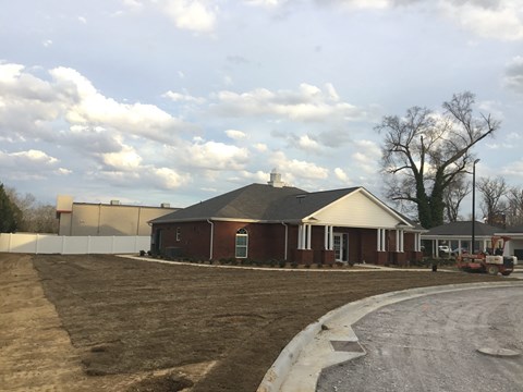 a red house with a dirt road in front of it