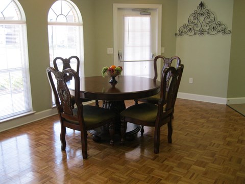 a dining room with a wooden table and chairs