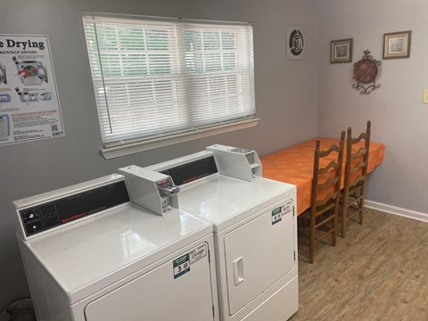 a dining room with two washers and a table with chairs