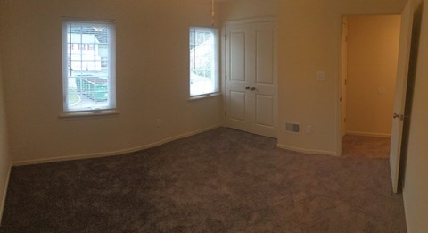 an empty living room with a door and window