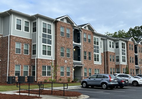 Apartment building with cars parked in front.