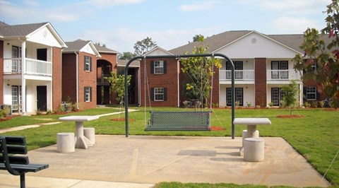 an empty playground in front of an apartment building