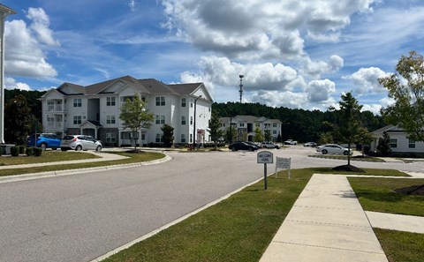 A residential area with apartment buildings and cars parked on the street.