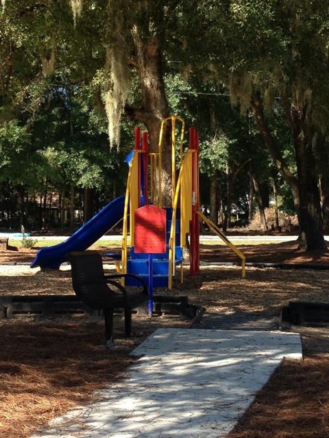 A playground with a blue slide and a red and yellow structure.