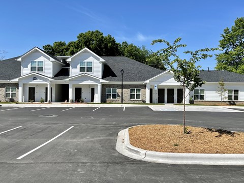 A large white building with a parking lot in front.