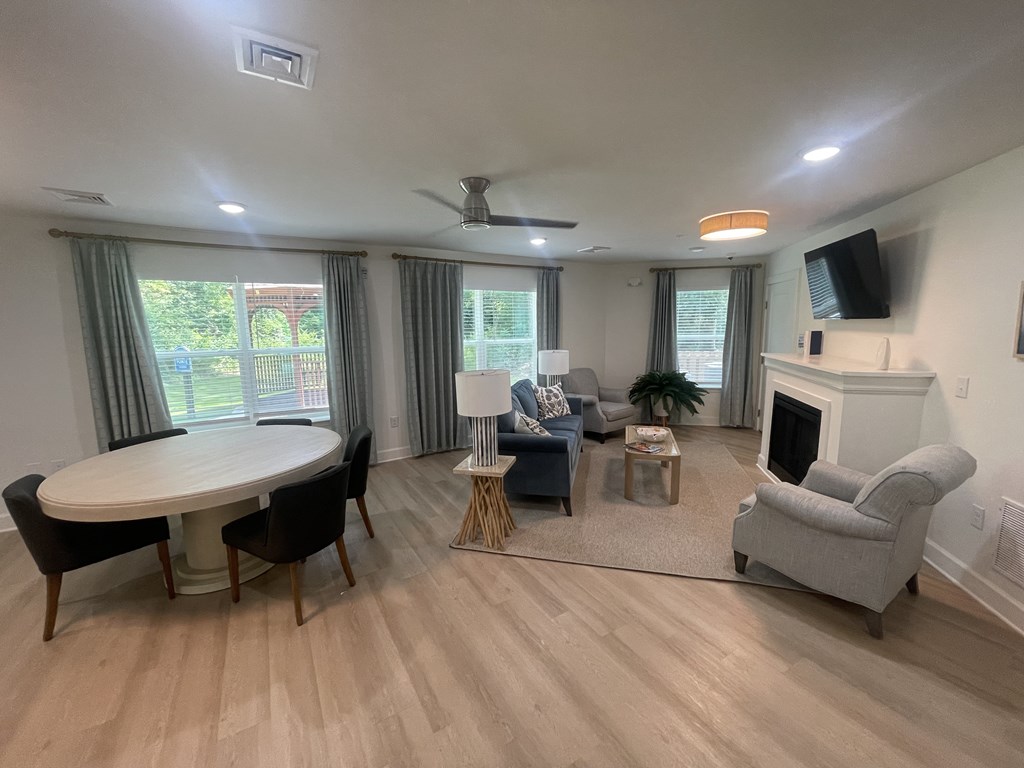 A living room with a fireplace, a TV, and a dining table.