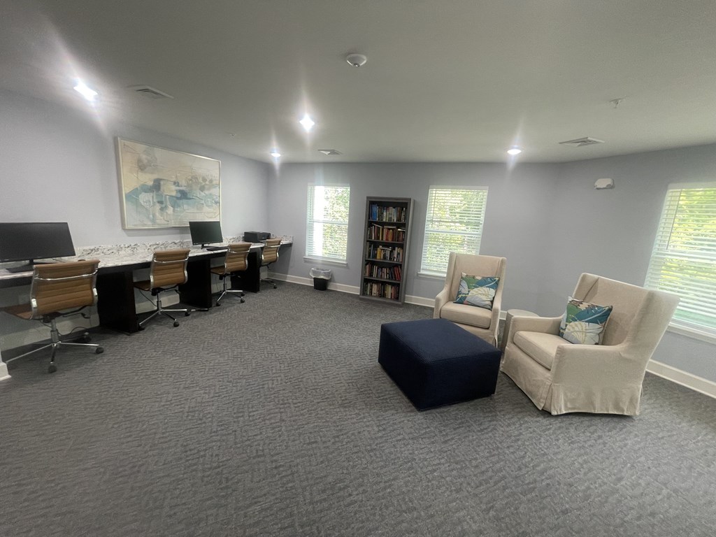 A room with grey carpet and a painting on the wall.