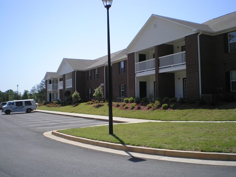 A street view of a building with a white van parked in front.