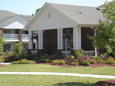 A house with a white porch and a grey roof.