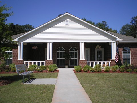 A white building with a bench in front of it.