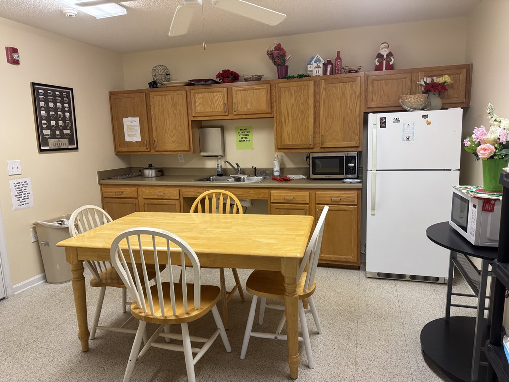 A kitchen with a table and chairs.