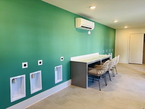 A room with green walls and a row of urinals on the wall.