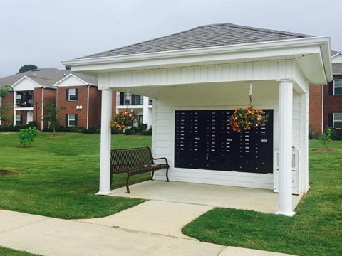 a gazebo with a bench on the side of a sidewalk