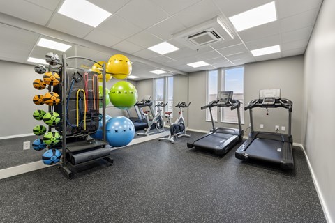 A gym with treadmills, exercise balls, and resistance bands.