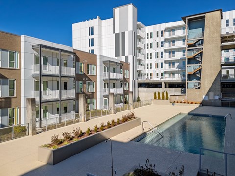 A modern building with a pool in front.
