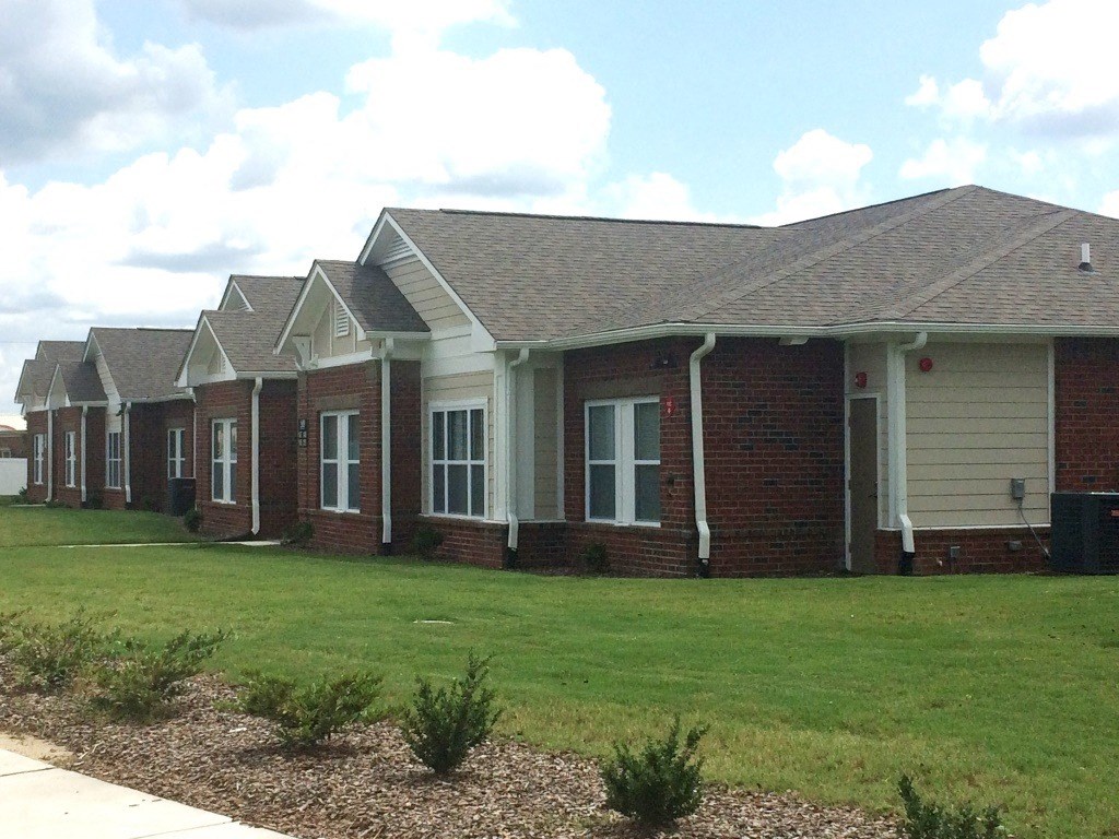 a row of brick houses with grass in front of them