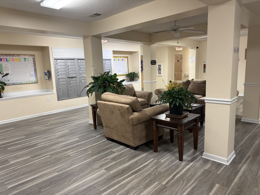 A room with a couch, a table, and a potted plant.