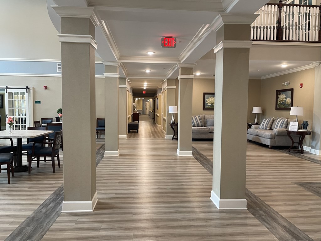 A long hallway with a red exit sign at the end.