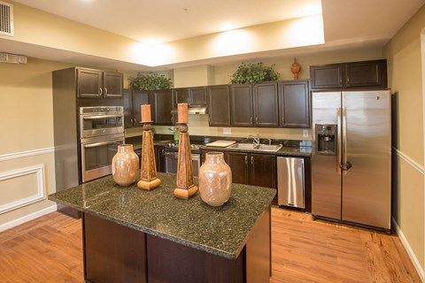 A kitchen with a granite countertop and stainless steel appliances.