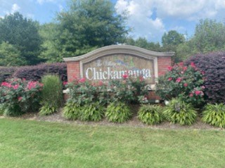 a sign for a chicken farm with flowers