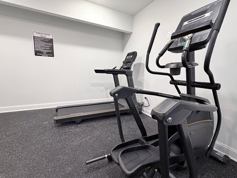 A gym with a treadmill and a stationary bike.