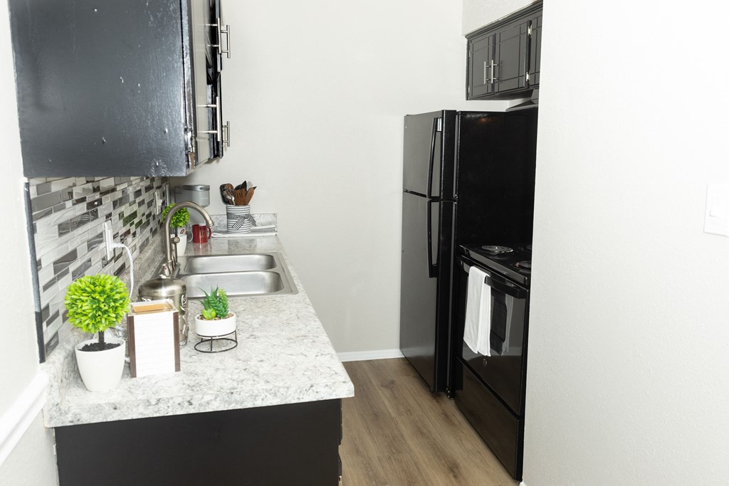 a kitchen with black appliances and a granite counter top and a black refrigerator