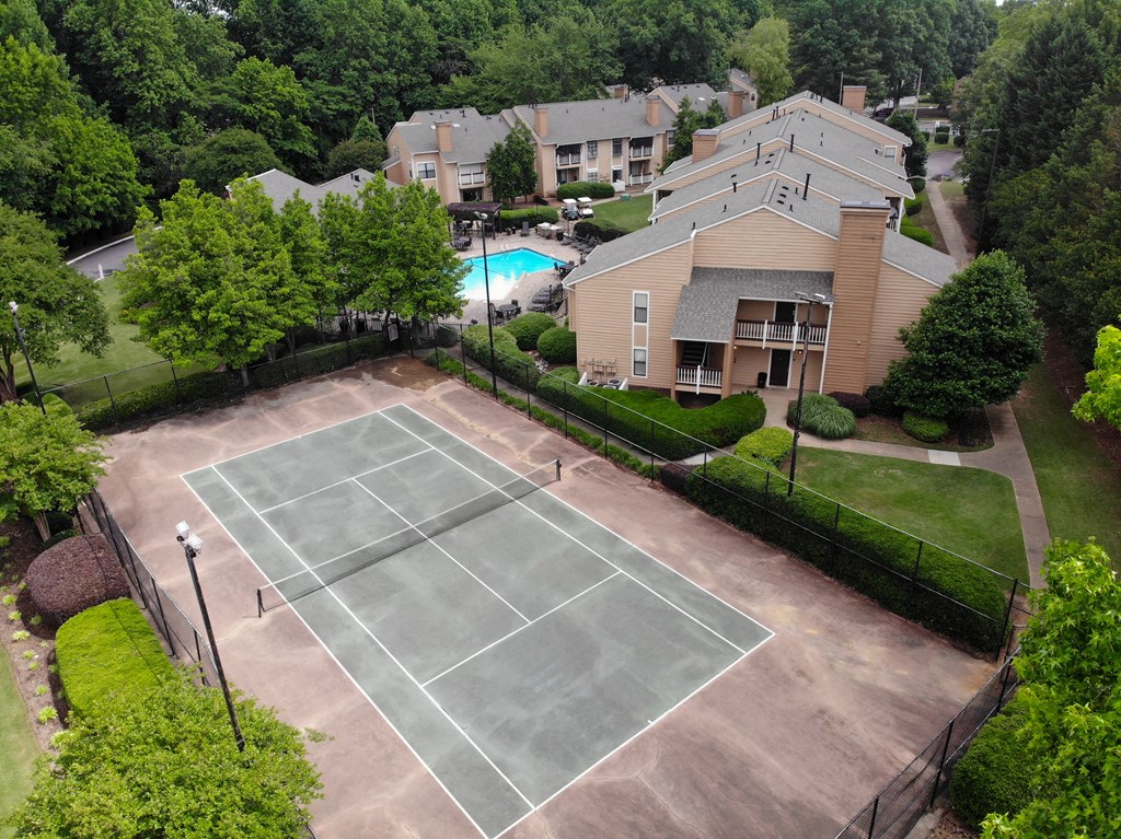 an aerial view of a tennis court and a house