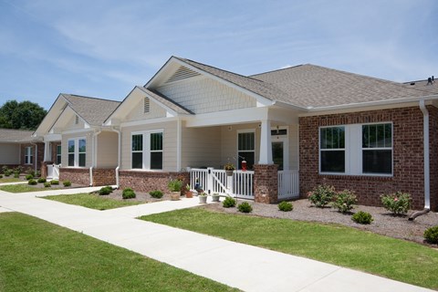 a house with a porch and a sidewalk in front of it