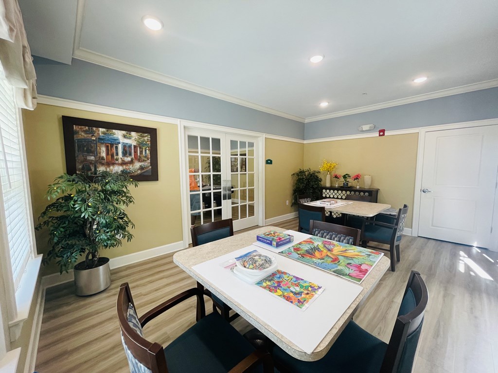 A dining room with a table surrounded by chairs.