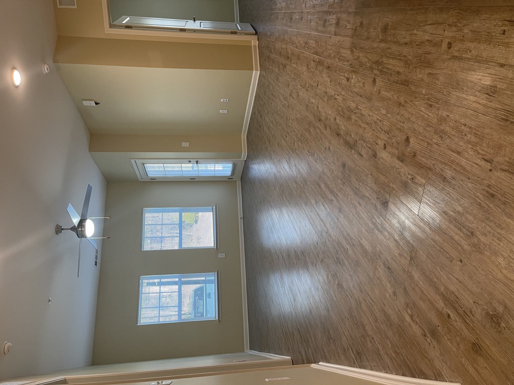 A room with a ceiling fan and a window.