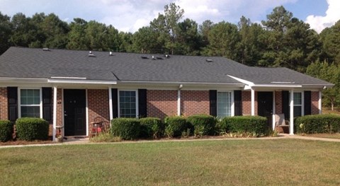 a house with a gray roof and some bushes
