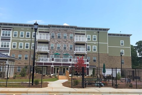 Apartment complex with a black fence in front.