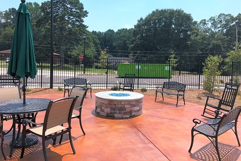 A patio with a table, chairs, and an umbrella.