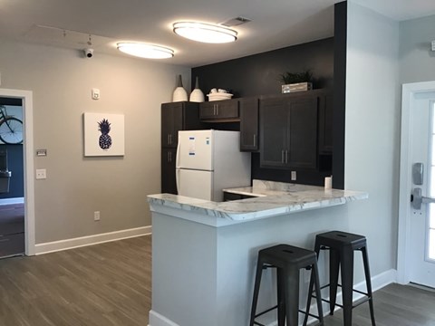 A kitchen with a white counter and bar stools.