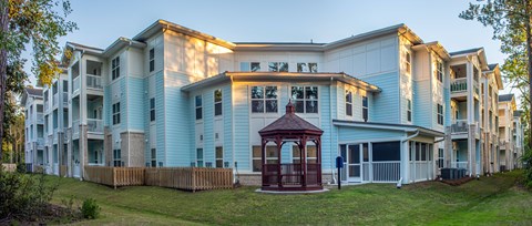 A large apartment complex with a gazebo in the front yard.
