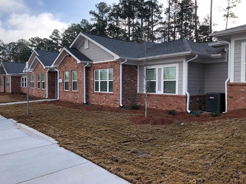 A row of houses with a white fence in front.