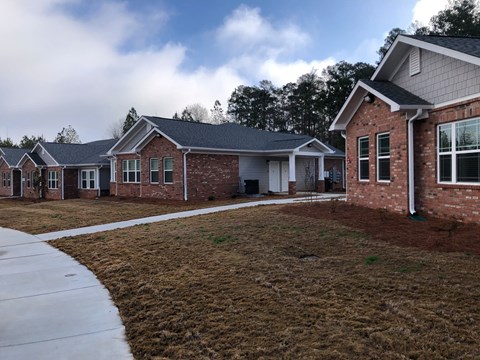 A row of houses with a sidewalk in front.