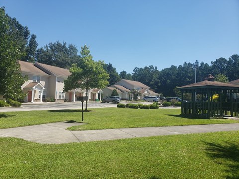 A sunny day in a residential area with houses and green lawns.