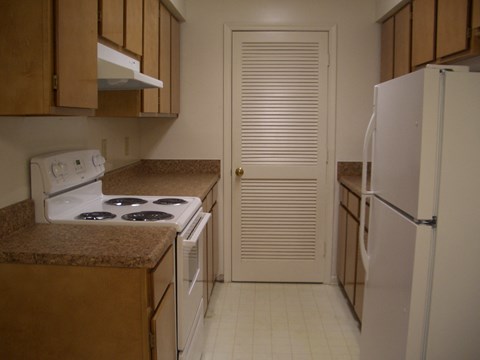 a kitchen with a stove refrigerator and a door