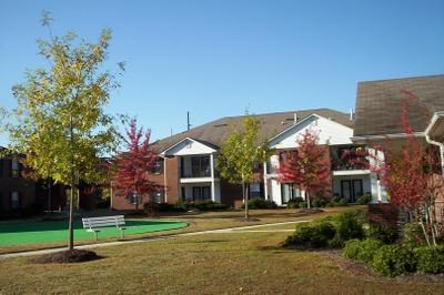 A residential area with a house, a tree, and a bench.
