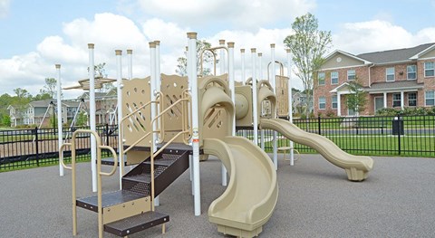 a playground with slides and other equipment in front of a house