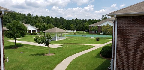 A gazebo is in the middle of a grassy area.