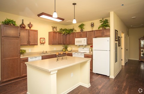 A kitchen with brown cabinets and a white fridge.