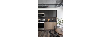 A modern kitchen with a wooden table and chairs.