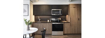A modern kitchen with dark brown cabinets and a white countertop.