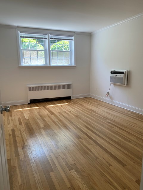 A room with a window and a radiator on the wall.