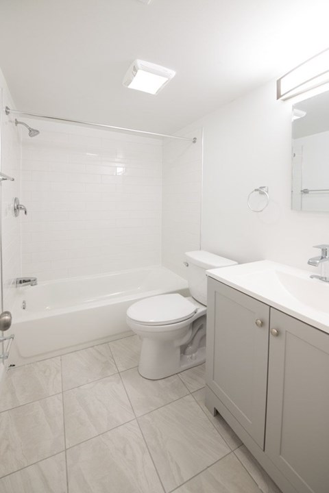 A white bathroom with a toilet, sink, and bathtub.