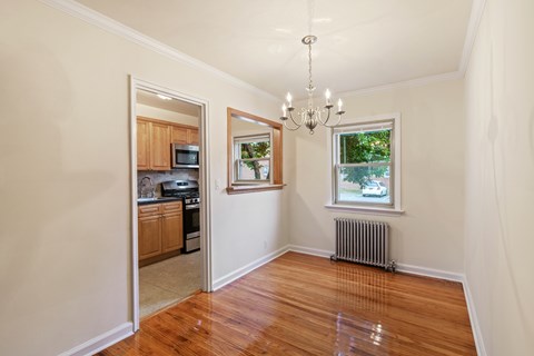 Dining room with a chandelier, a window, and a door leading to a kitchen