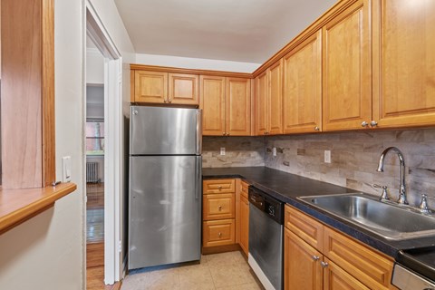 A kitchen with wooden cabinets and a stainless steel appliances