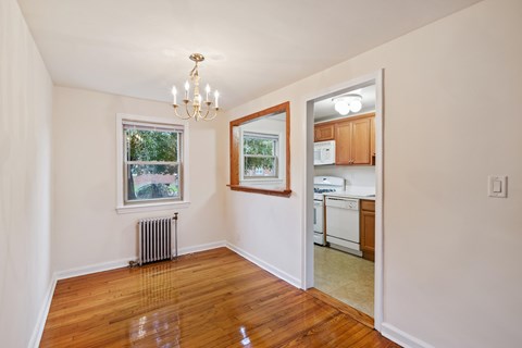 Dining room with a chandelier, a window, and a door leading to a kitchen